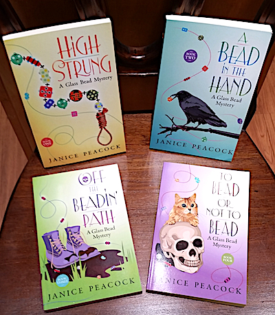 Four book covers with illustrations of story elements including beads.